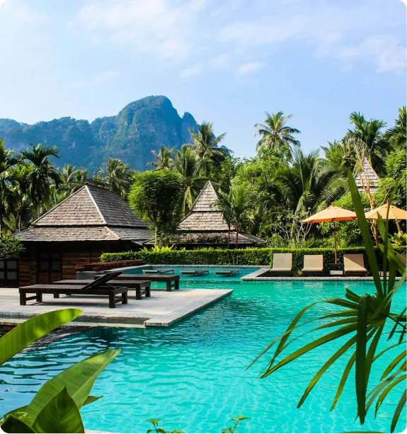 Resort pool framed by palms and limestone peaks