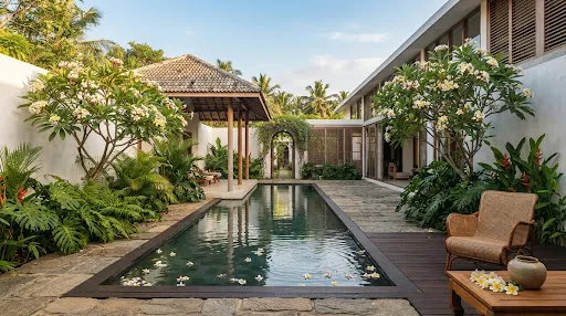 A courtyard pool framed by frangipani trees and tropical modernist villas